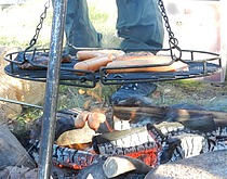 Pølser og hamburgere grilles på bål. Govvat/foto: Inga-Maja Jernsletten