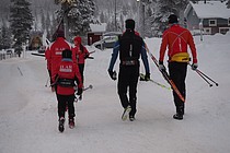 Ilarskiløpere på vei til skiløypa sammen med sveitsiske langslagskiløpere. I midten går Dario Cologna.  Foto: Charles Petterson
