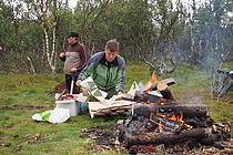 Kokken tilbereder maten som skal graves ned i kokegropa.  Govat/foto: Charles Petterson.